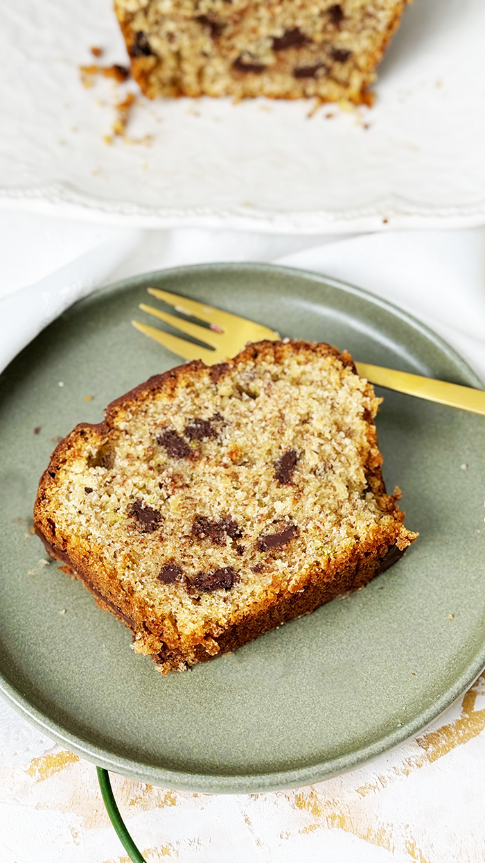 Ein saftiger Zucchinikuchen mit Schokolade, veredelt durch eine glänzende Glasur und Schokostückchen, ideal für gemütliche Kaffeepausen.